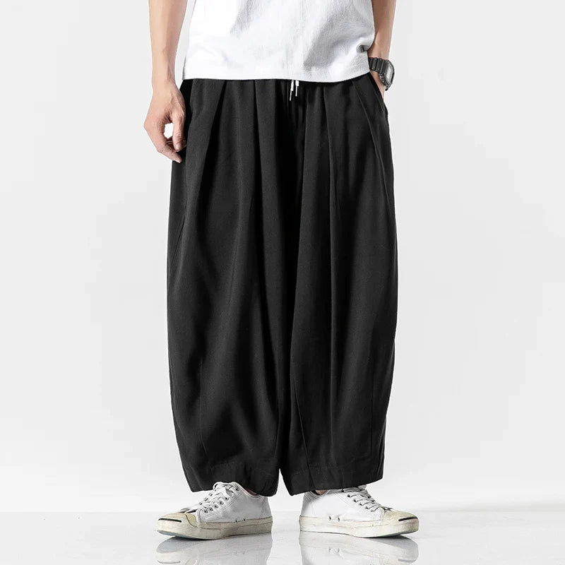 Men's baggy drawstring harem pants in black, front view