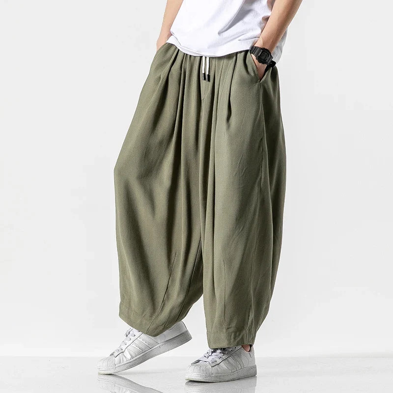 Side view of men's army green baggy harem pants with cuffed ankles