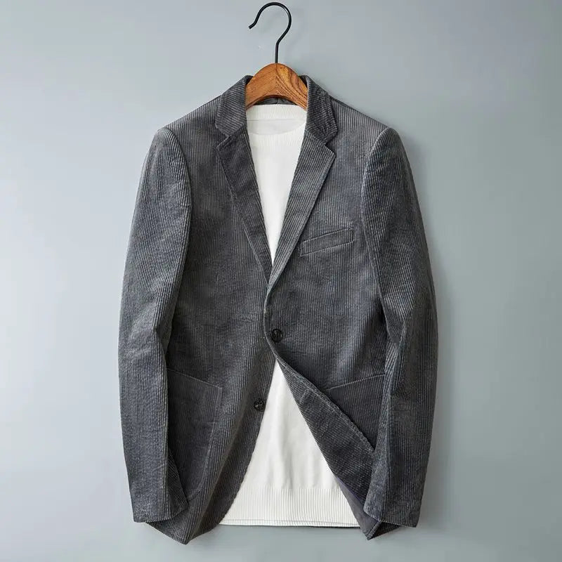 Men's gray corduroy two-button blazer worn open over a white knit shirt