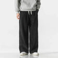 Men's relaxed wide-leg corduroy pants in black, front view