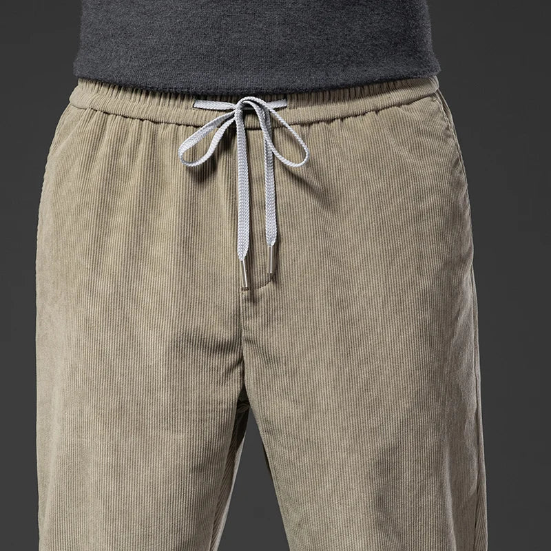 Close-up of the elastic waistband with contrast drawstring on khaki corduroy pants