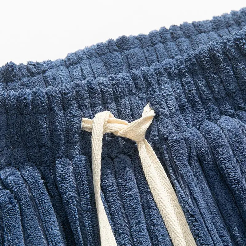 Close-up of drawstring waistband on blue wide-wale corduroy pants