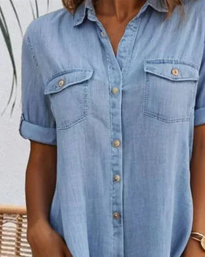 Close-up of chest flap pockets on a light blue denim shirt dress