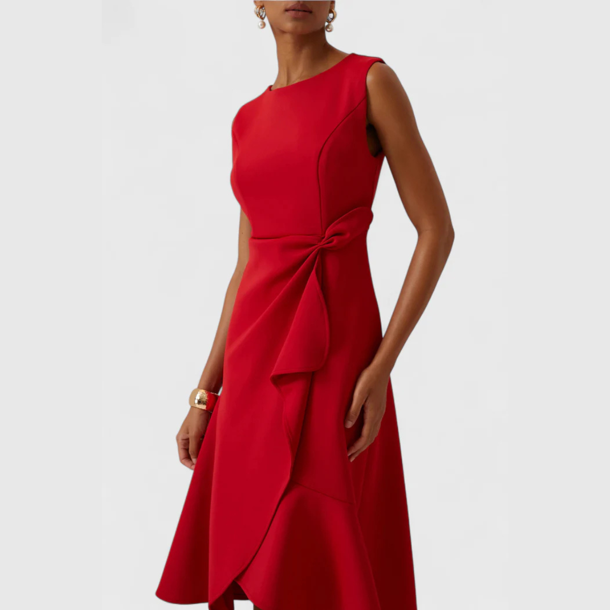 Close-up of the twist-knot waist detail on the red midi dress