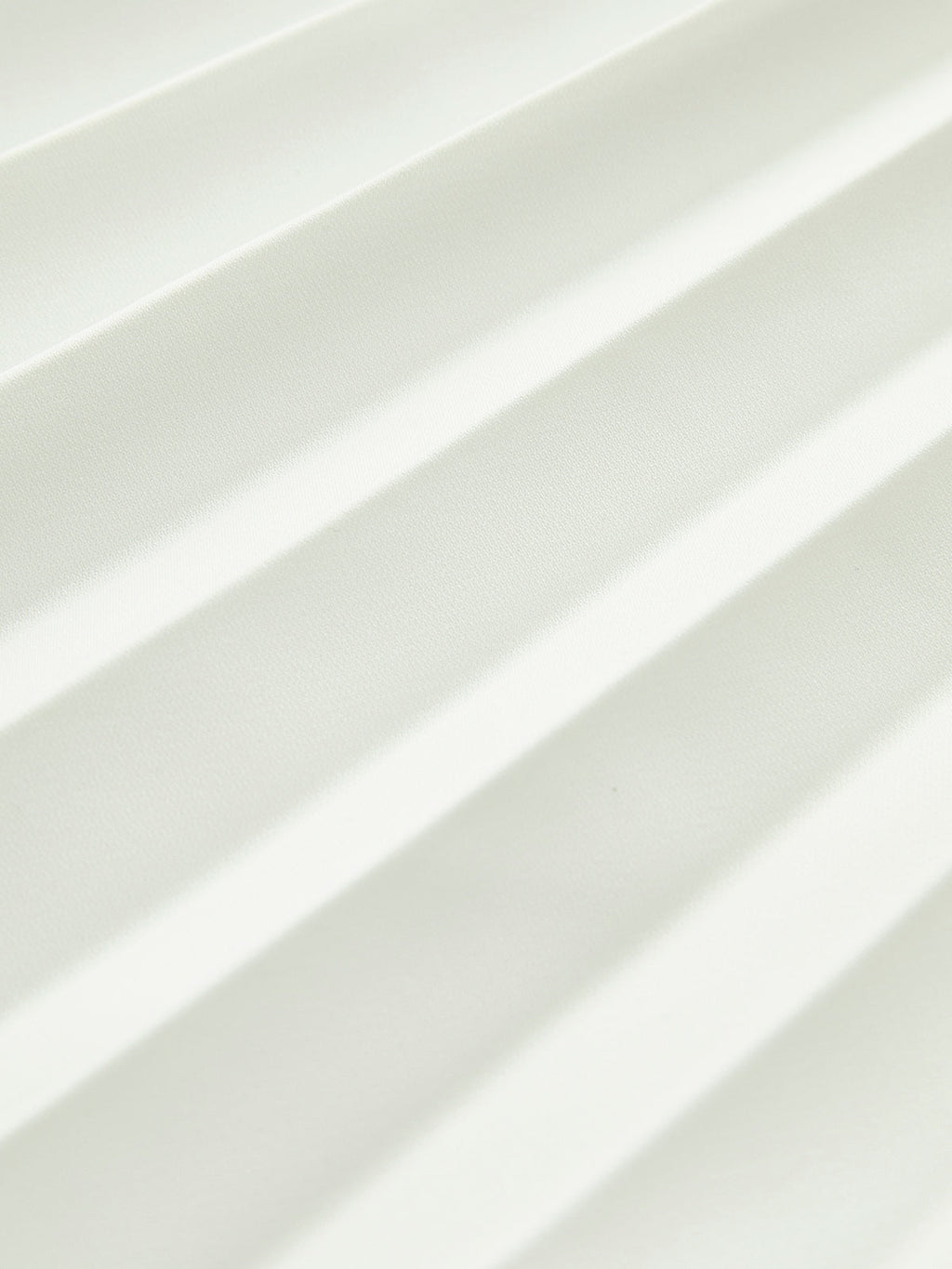 Close-up of the fine pleats on the white maxi skirt