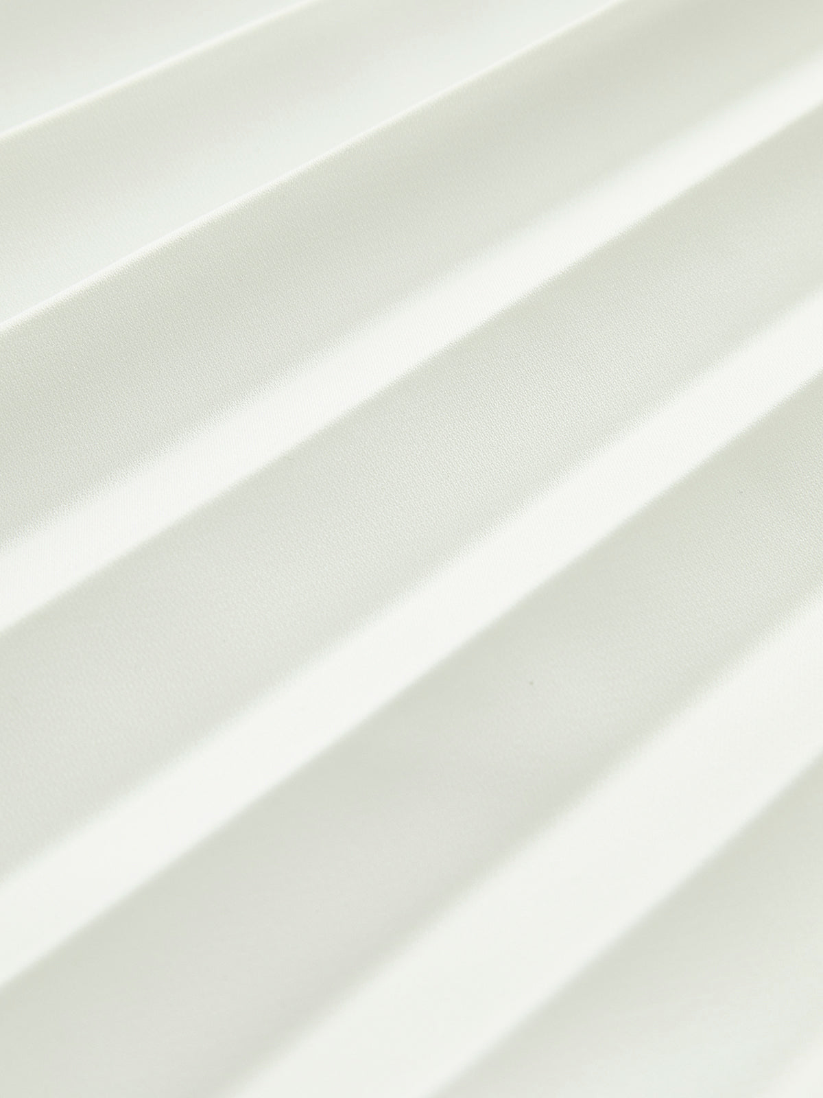 Close-up of the fine pleats on the white maxi skirt