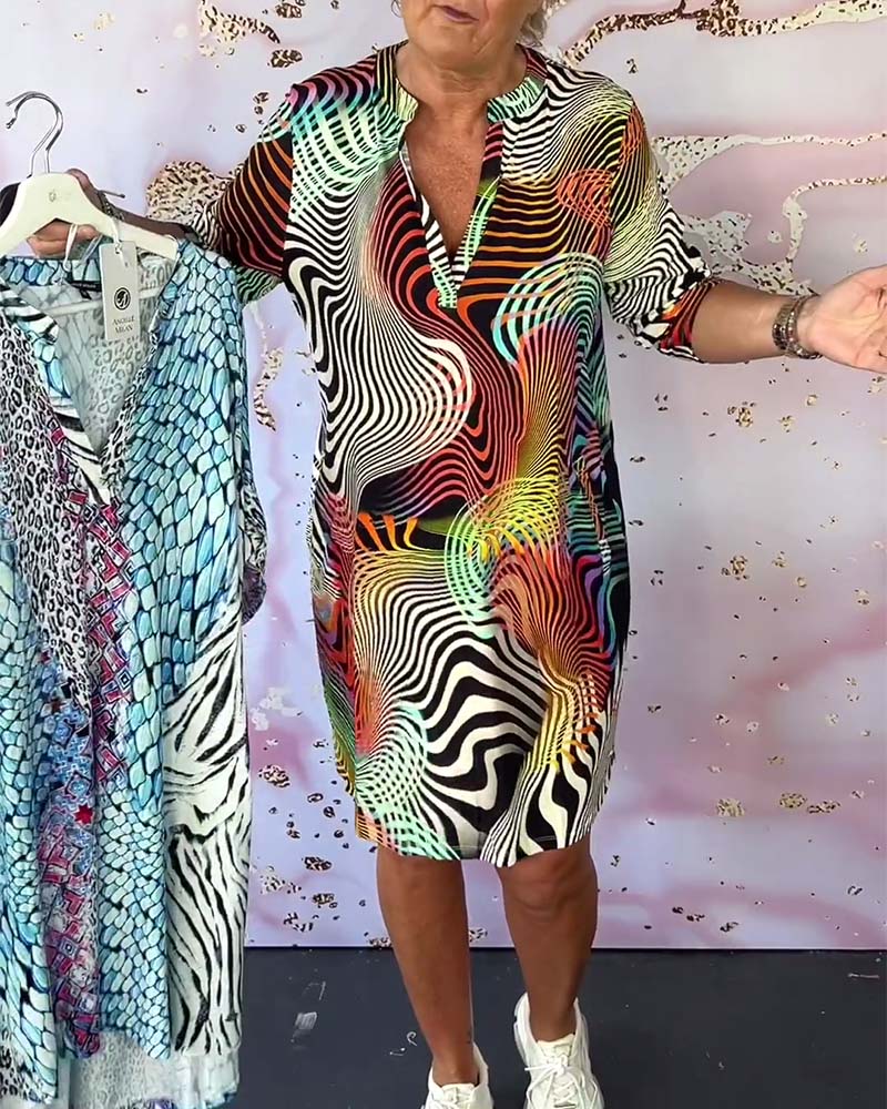 Model in multicolor printed shift dress holding hangers with other dresses