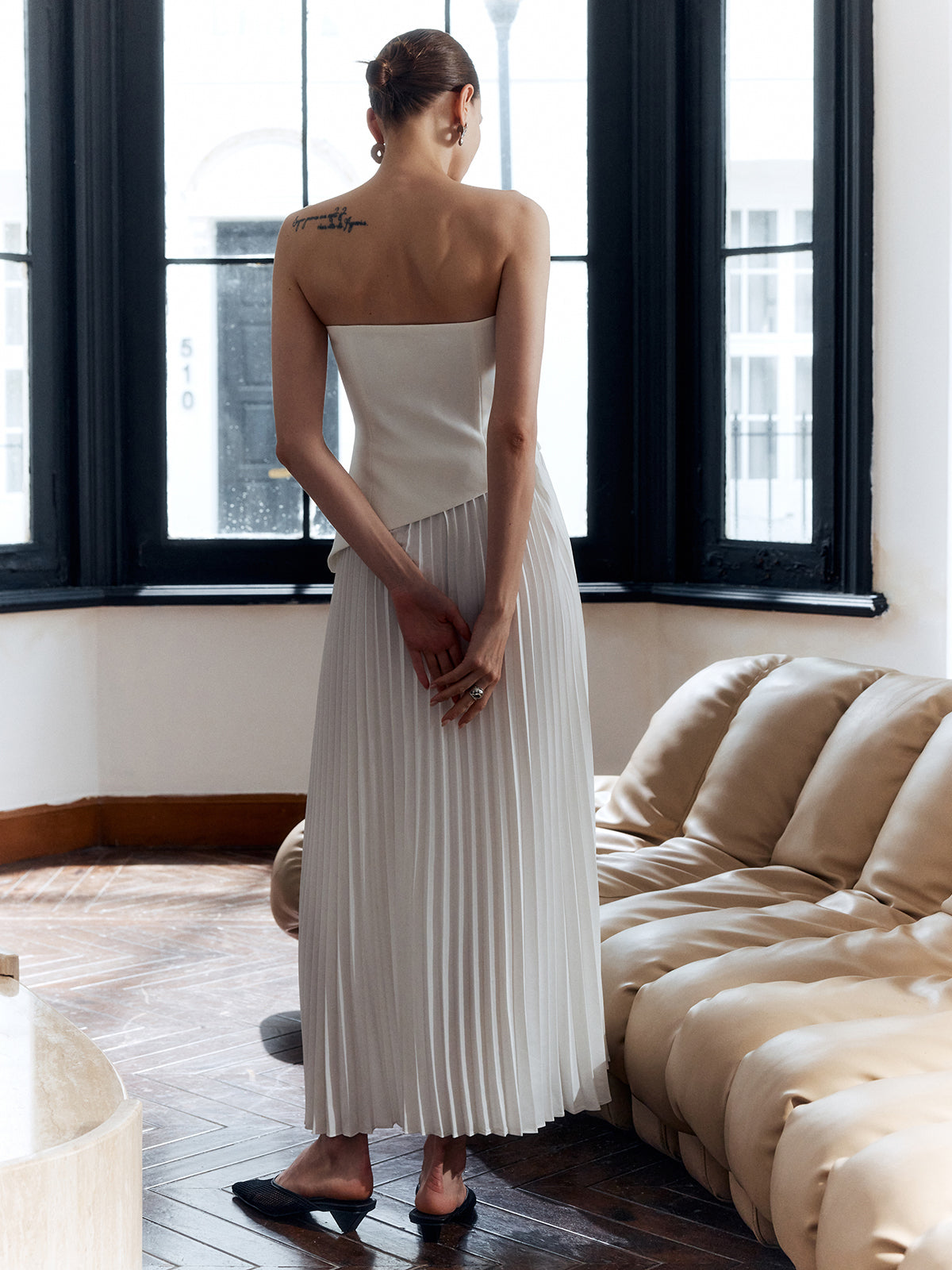 Back view of women's white strapless pleated maxi dress