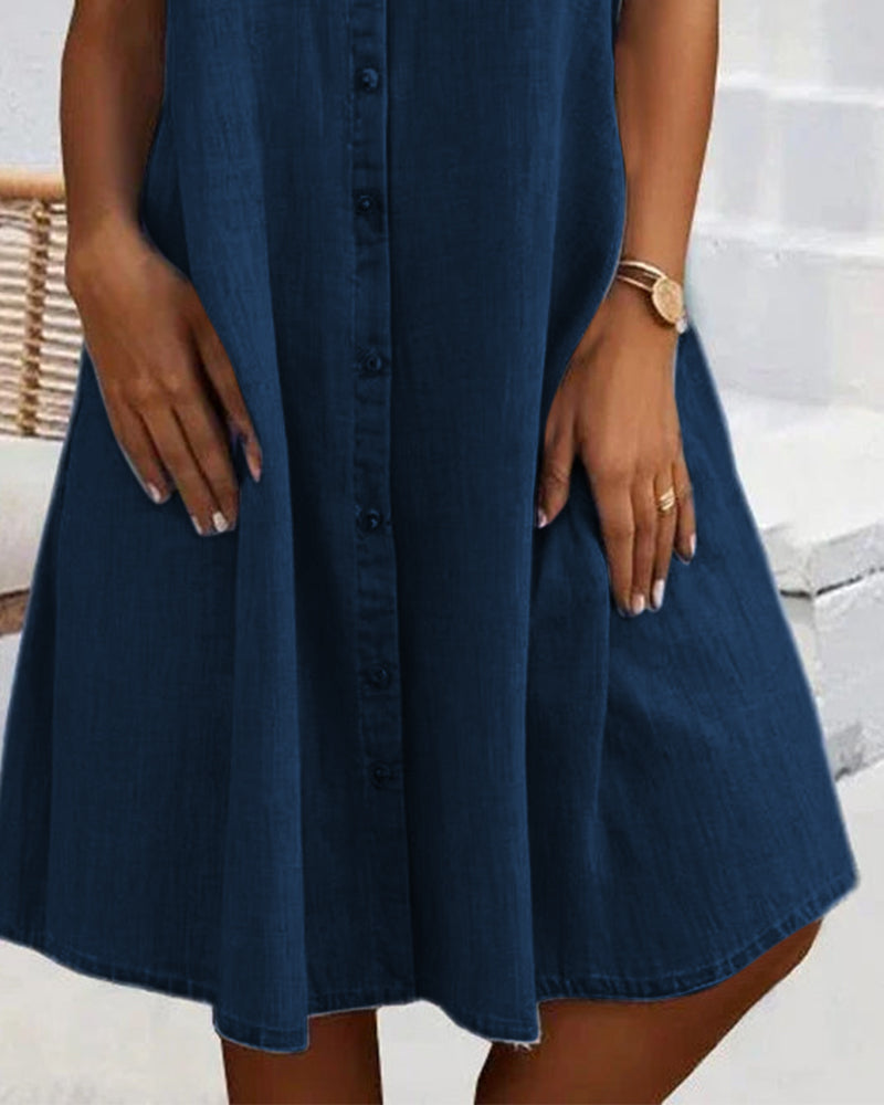 Close-up of the flared skirt on a dark blue denim shirt dress